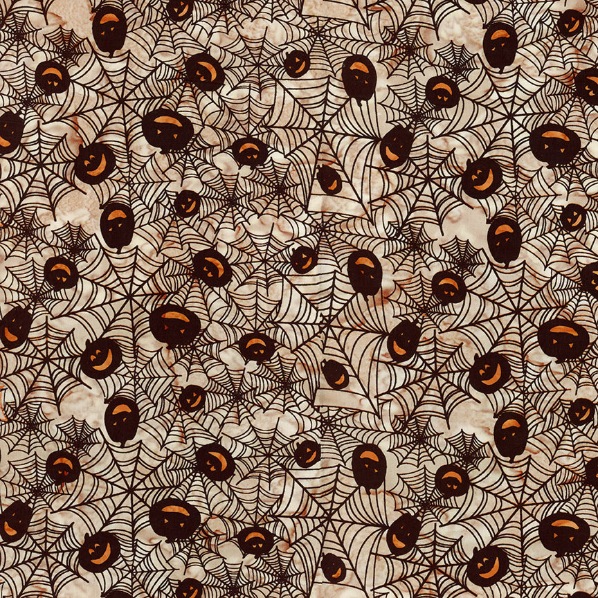 Fabric pattern Mocha me Crazy: hand-stamped spiderweb with jack o lantern faces on a light tan background from The Whispering Hollows collection which features fun Halloween images, with colors invoking midnight skies, as well as favorite seasonal hues. The Batiks Collections by Riley Blake are produced in state-of-the-art facilities with the best Tjap designers and makers, color experts, and stamp prodigies.