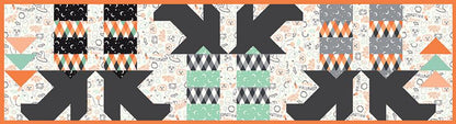 The Witches Feet Table Runner Kit includes pattern and fabric for table runner top and binding. Backing is not included. Fabric featured is Frank and Friends by My Mind's Eye. Pattern is by Block Party Quilt Co. Finished size is 14" x 54". Kit comes in a solid box with a printed belly band label. Box size is approximately 6" x 10" x 2 1/2".