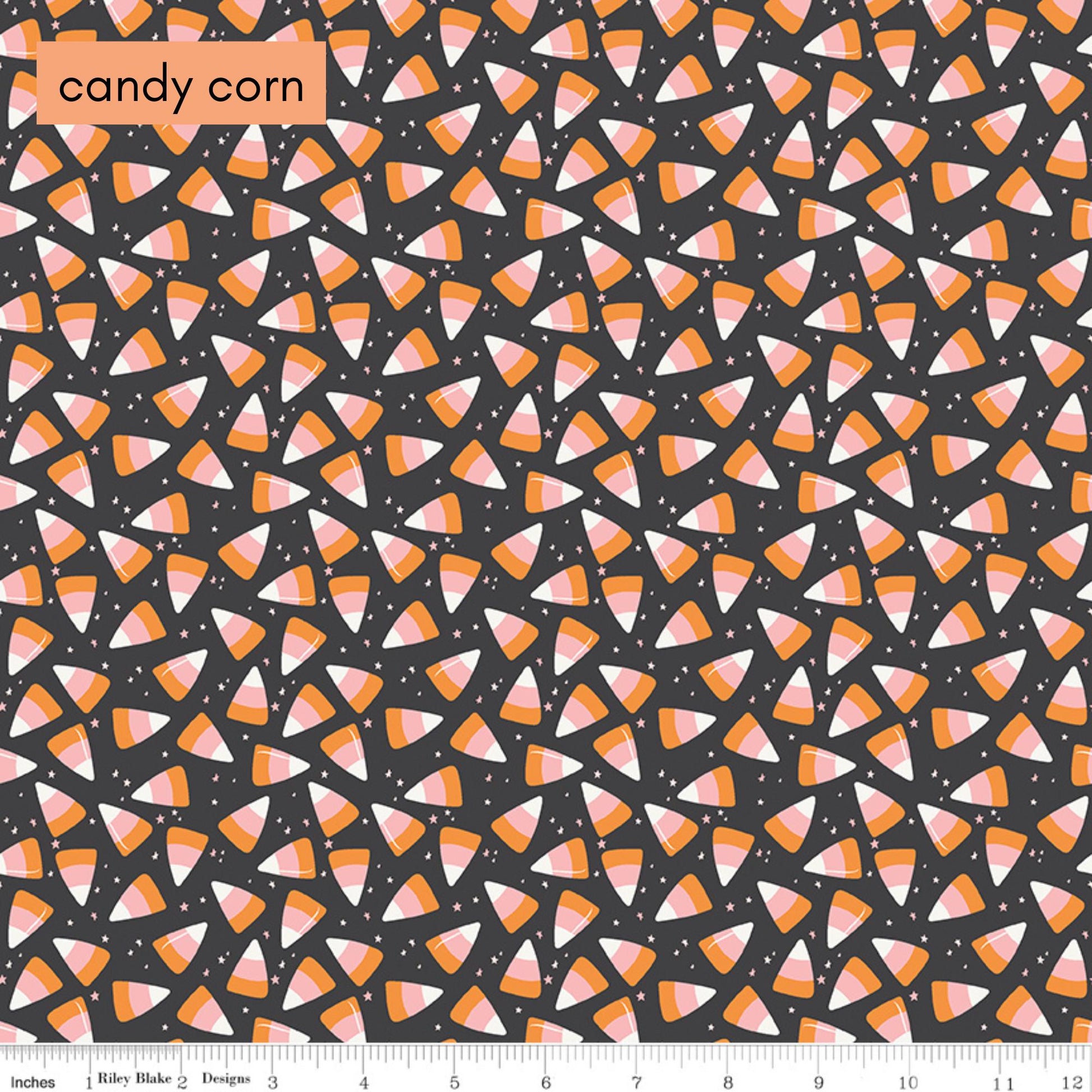 Pattern of candy corn on a black background with a ruler at the bottom.