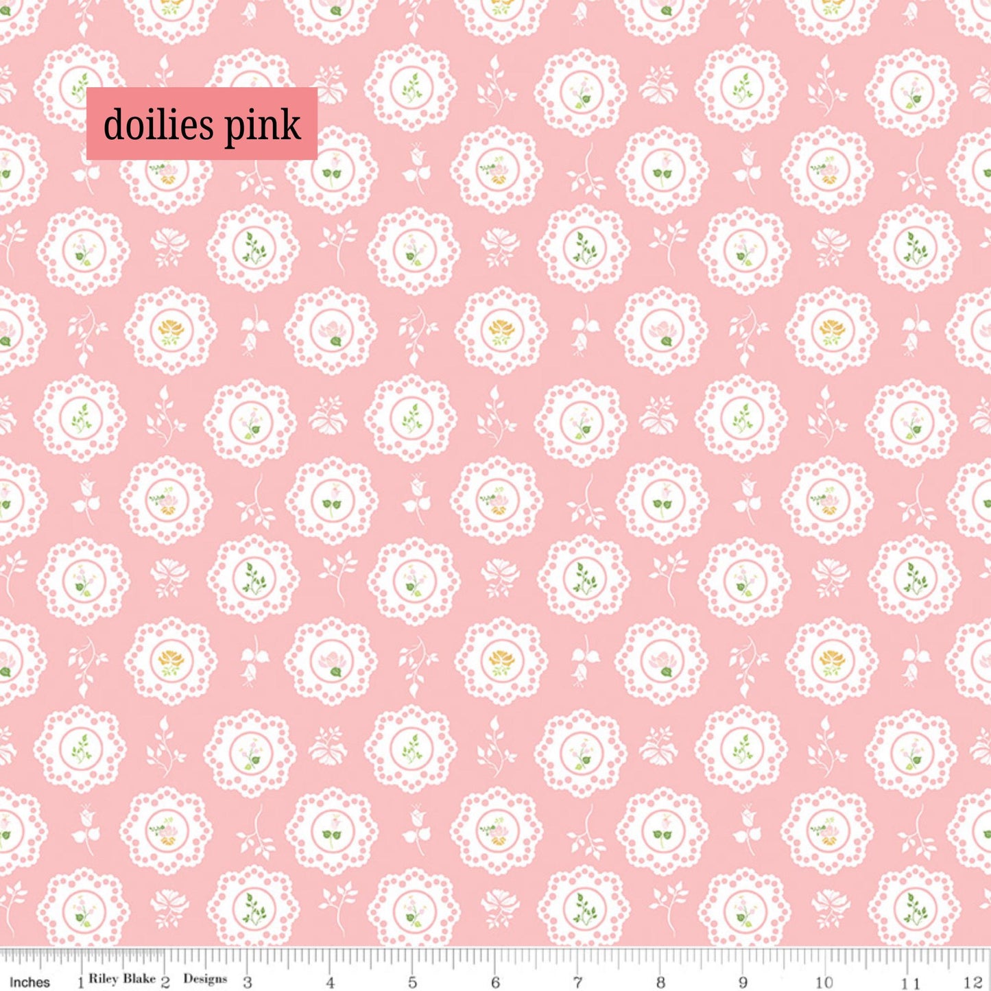 Pink fabric with white lace doily patterns and small green details