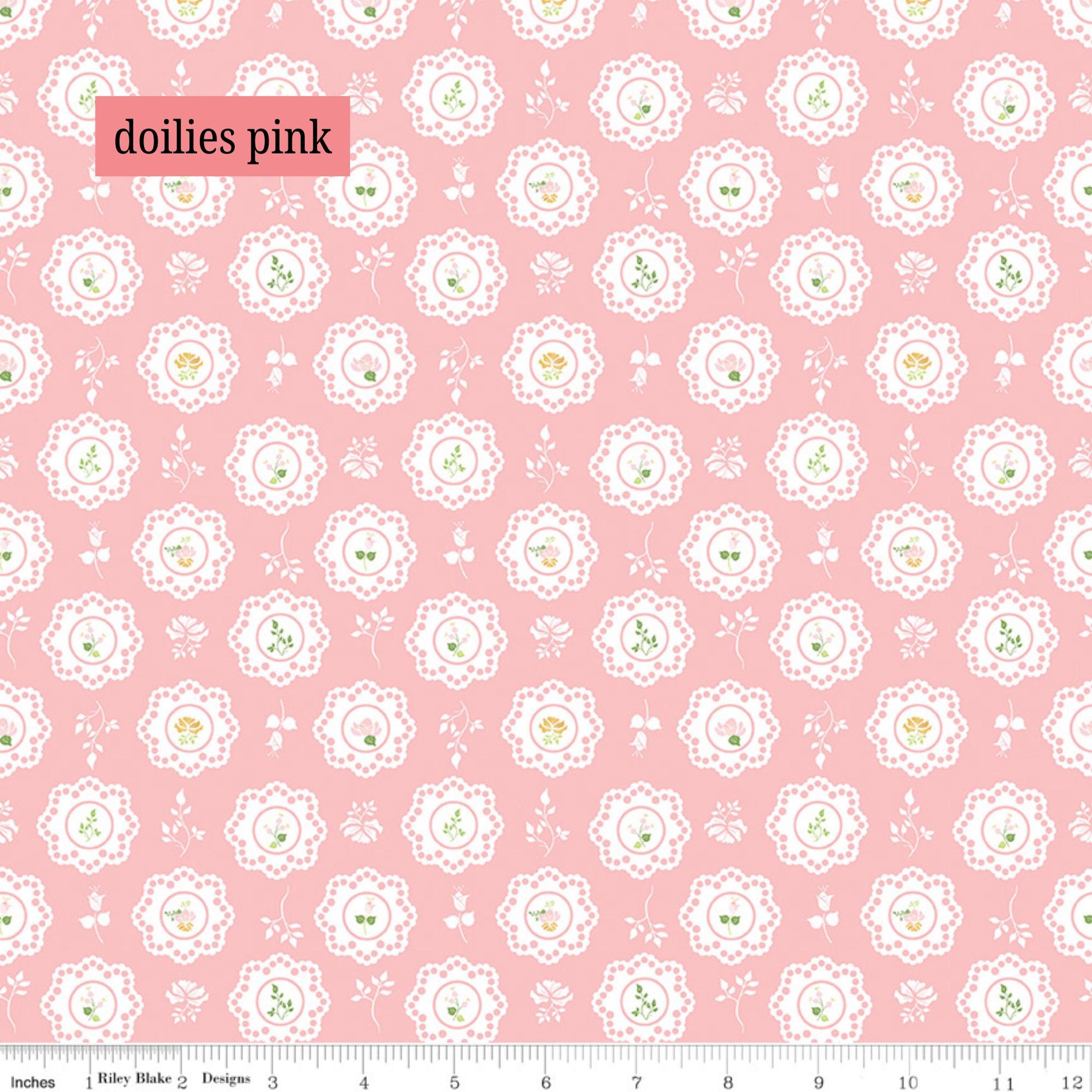 Pink fabric with white lace doily patterns and small green details