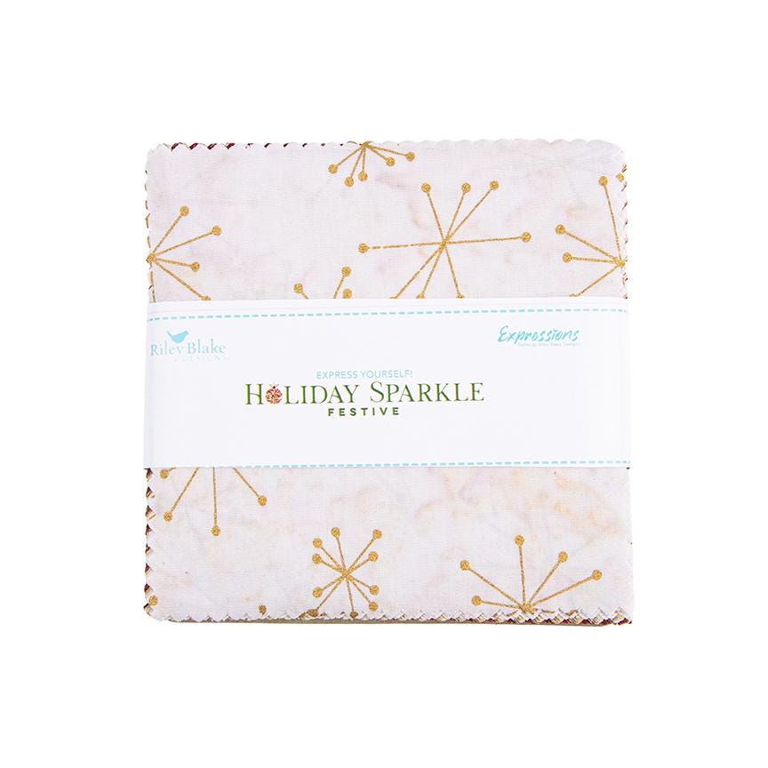 This holiday collection features unique, handcrafted batik prints ethically sourced and hand-dyed by master artisans in Indonesia. The Festive colorway highlights rich Christmas reds, deep greens, and warm accent tones embedded with shimmering metallic highlights. The designs feature swirling holiday baubles, starbursts, and intricate geometric/organic line work (such as the metallic circuit and star patterns) that catch the light, adding a sophisticated glimmer to seasonal quilts, tree skirts, table runner