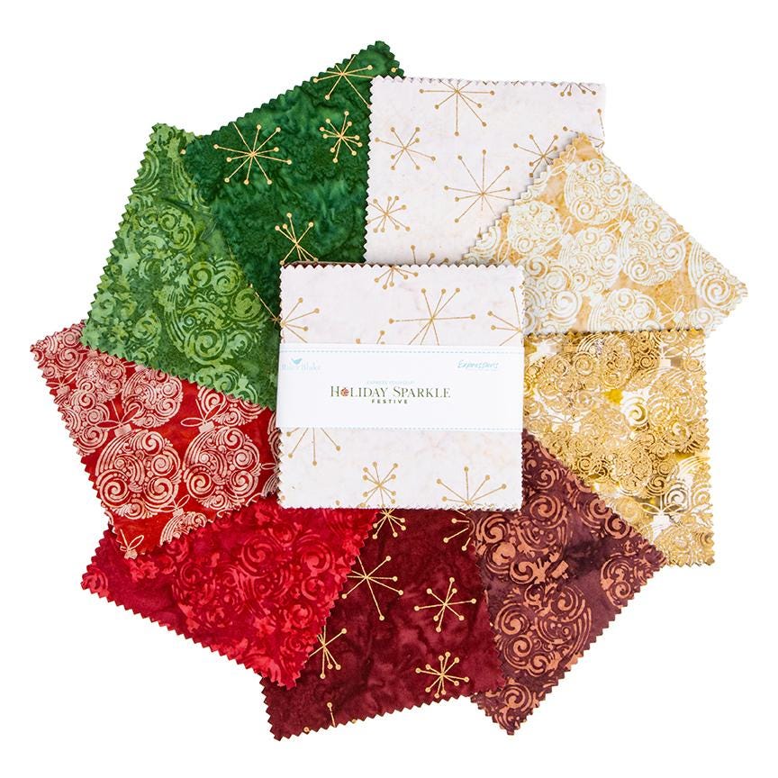 This holiday collection features unique, handcrafted batik prints ethically sourced and hand-dyed by master artisans in Indonesia. The Festive colorway highlights rich Christmas reds, deep greens, and warm accent tones embedded with shimmering metallic highlights. The designs feature swirling holiday baubles, starbursts, and intricate geometric/organic line work (such as the metallic circuit and star patterns) that catch the light, adding a sophisticated glimmer to seasonal quilts, tree skirts, table runner